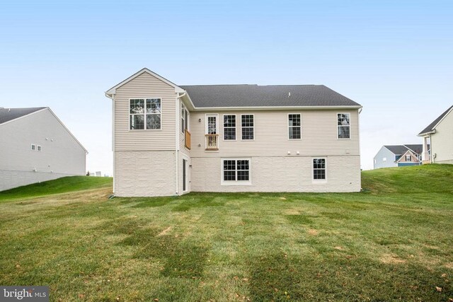 rear view of property featuring a lawn