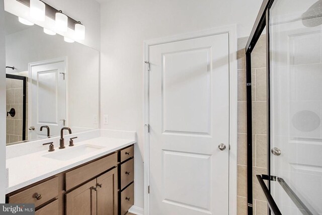 bathroom featuring vanity and an enclosed shower