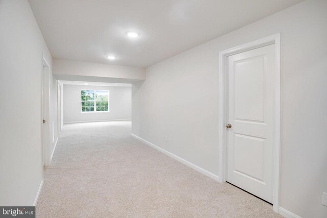 hallway featuring light colored carpet