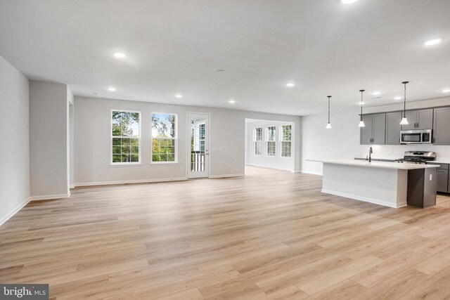 unfurnished living room with sink and light hardwood / wood-style flooring