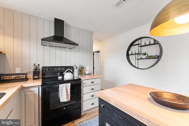 kitchen with butcher block counters, visible vents, electric range, and wall chimney range hood