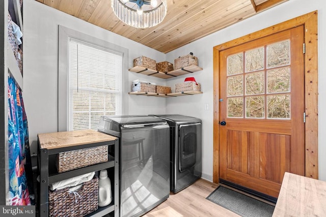 clothes washing area with laundry area, light wood-type flooring, wooden ceiling, and washing machine and dryer