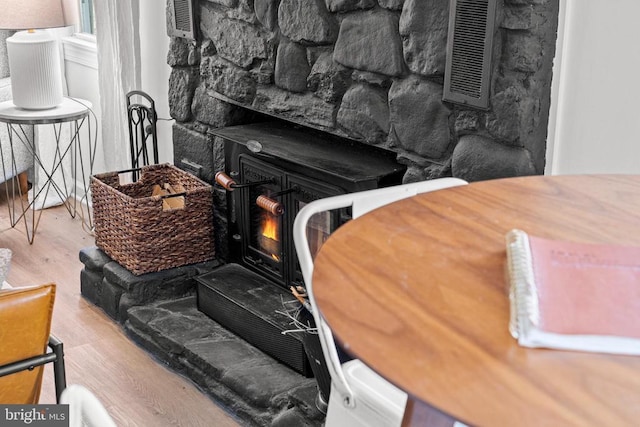 details with a wood stove and wood finished floors