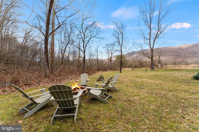 view of yard with an outdoor fire pit and a mountain view