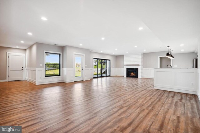 unfurnished living room with a fireplace and light wood-type flooring