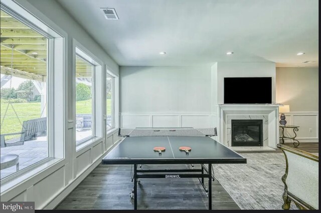 game room with a premium fireplace and dark hardwood / wood-style flooring