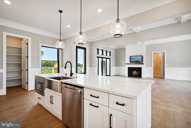 kitchen with white cabinetry, pendant lighting, light stone countertops, and appliances with stainless steel finishes