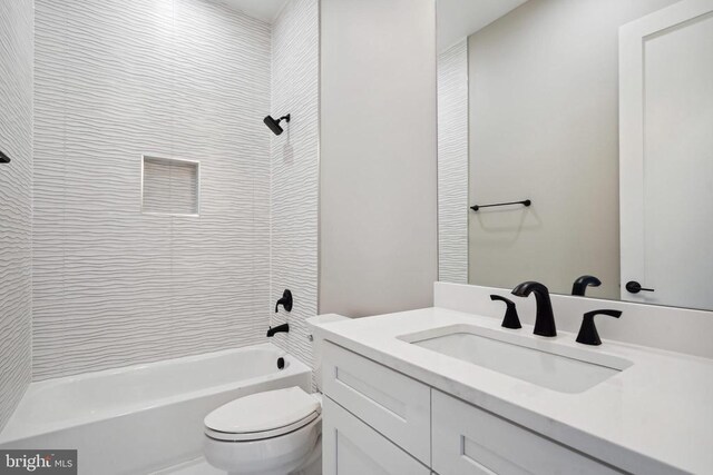 full bathroom with vanity, tiled shower / bath, and toilet