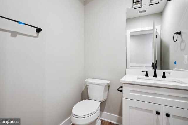 bathroom featuring hardwood / wood-style flooring, vanity, and toilet