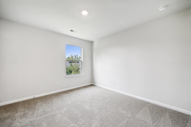 empty room featuring visible vents, baseboards, and carpet flooring