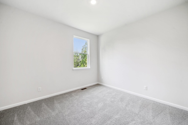 empty room with visible vents, baseboards, and carpet floors