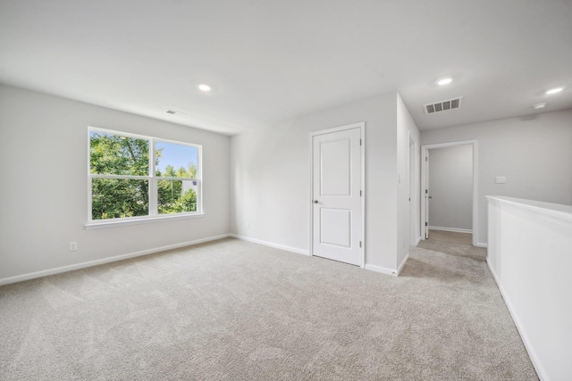 spare room featuring carpet, recessed lighting, baseboards, and visible vents