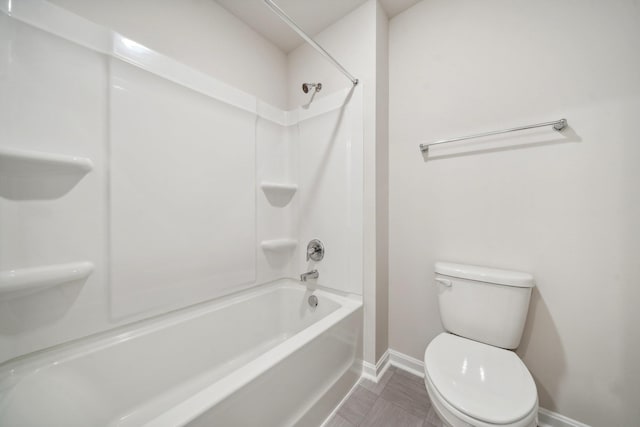 bathroom with toilet, shower / bath combination, and baseboards