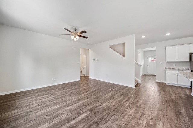 unfurnished living room featuring stairs, recessed lighting, baseboards, ceiling fan, and dark wood-style flooring