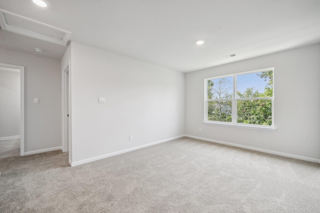 spare room featuring carpet, baseboards, visible vents, attic access, and recessed lighting