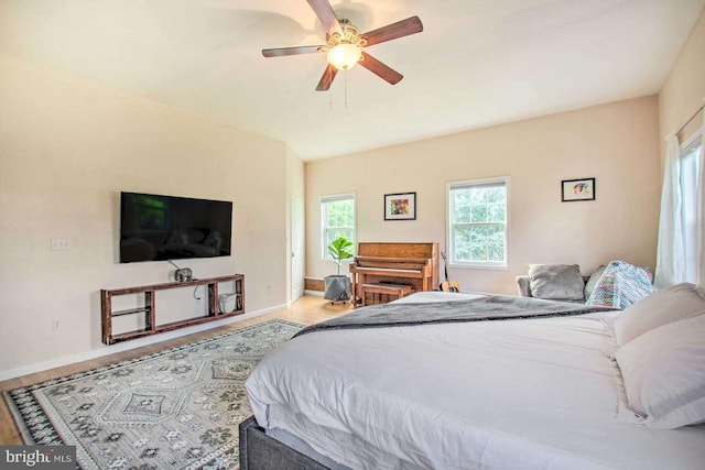 bedroom featuring a ceiling fan, baseboards, and wood finished floors