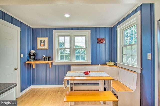 dining area with wood finished floors, baseboards, and ornamental molding