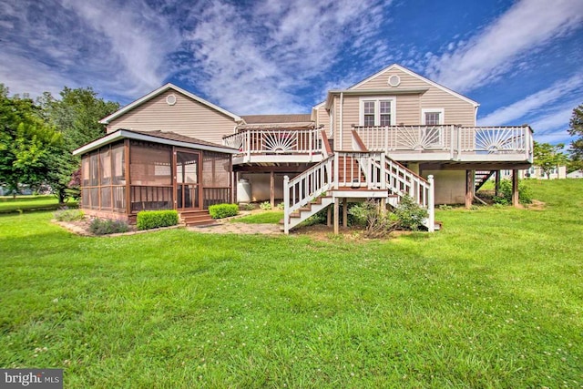 back of property featuring a deck, stairs, a yard, and a sunroom