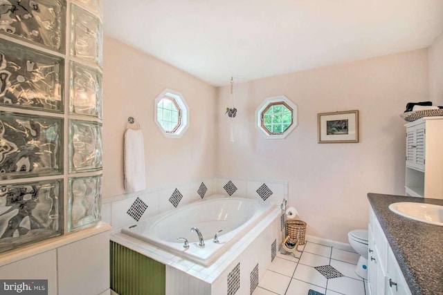 bathroom featuring tile patterned floors, toilet, baseboards, a bath, and vanity