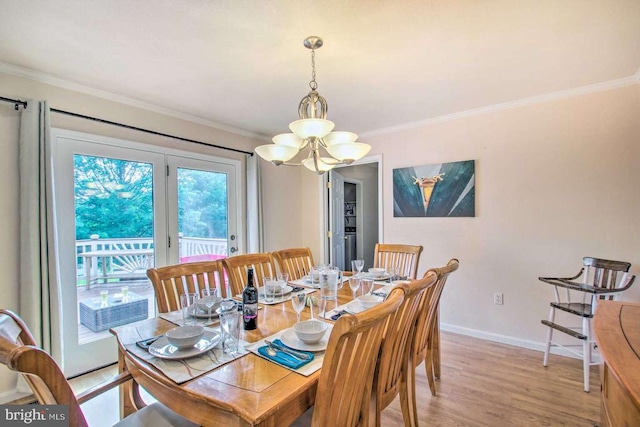 dining room with light wood finished floors, baseboards, an inviting chandelier, and ornamental molding