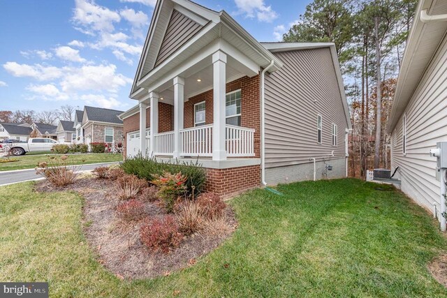 view of side of home with a porch and a yard