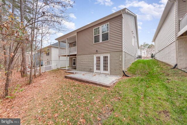 back of house featuring a yard, a patio area, and a balcony