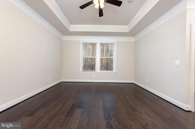 unfurnished room featuring ornamental molding, dark wood-type flooring, ceiling fan, and a tray ceiling