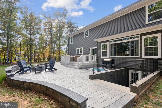 view of patio / terrace featuring a deck and an outdoor fire pit