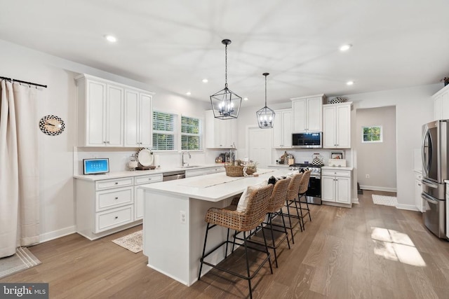 kitchen with a breakfast bar, white cabinetry, and stainless steel appliances