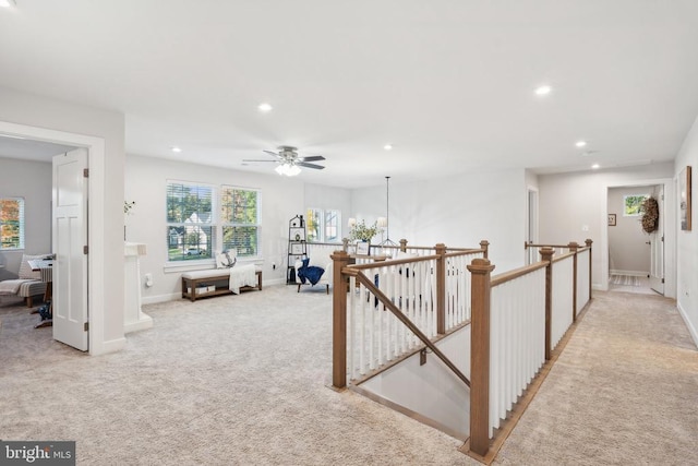 hall featuring recessed lighting, baseboards, an upstairs landing, and light colored carpet