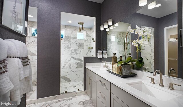 bathroom with a tile shower and vanity