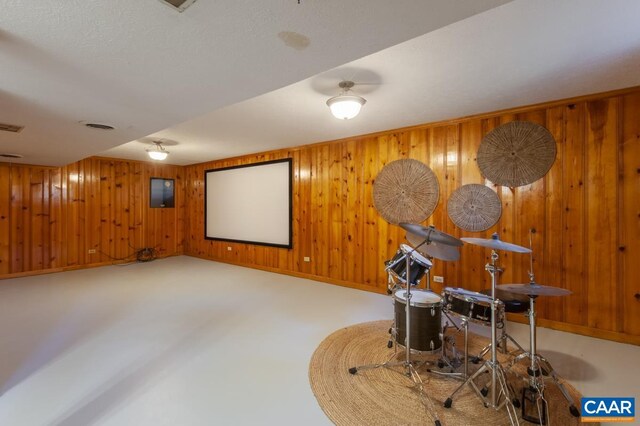 home theater featuring wooden walls and baseboards