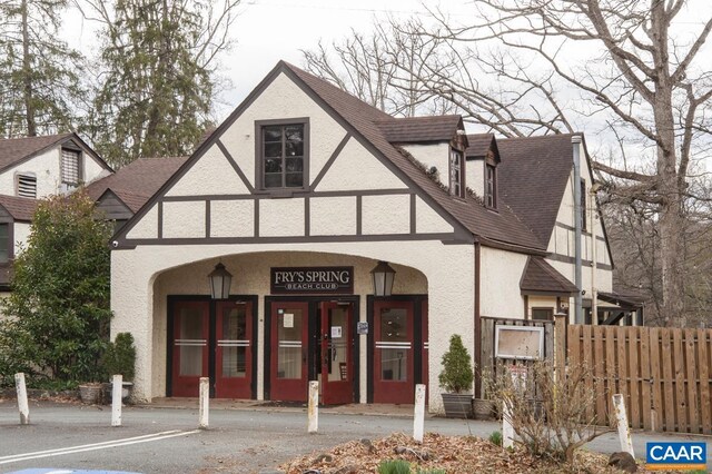 exterior space featuring a shingled roof, fence, and stucco siding