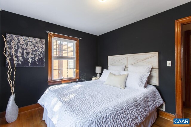 bedroom featuring baseboards and wood finished floors