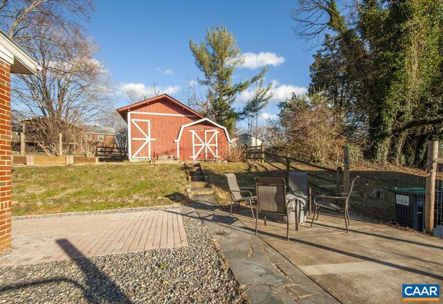 view of barn with cooling unit, fence, and a lawn