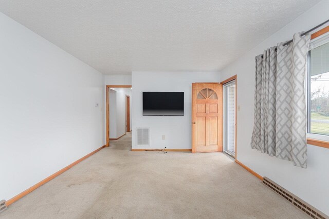 unfurnished living room featuring a textured ceiling and carpet