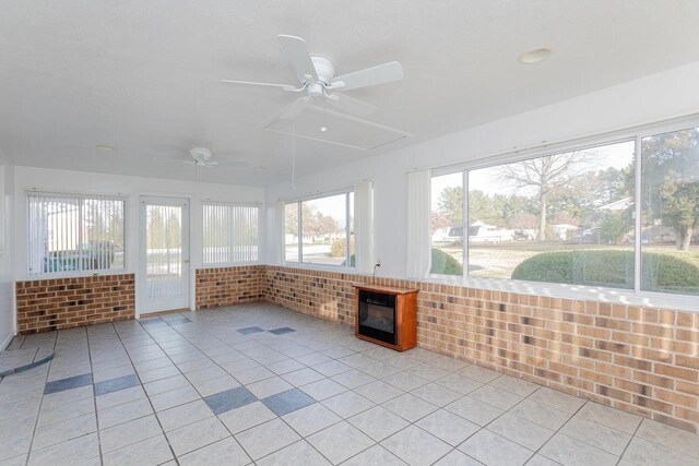 unfurnished sunroom with ceiling fan