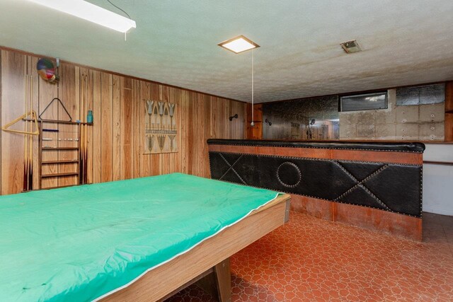 rec room with a textured ceiling, wooden walls, and billiards