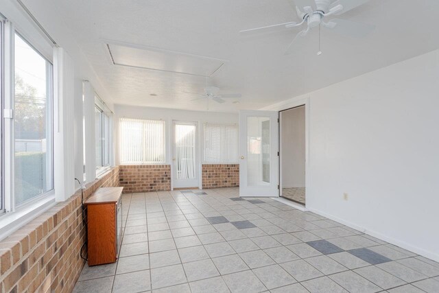 unfurnished sunroom featuring ceiling fan