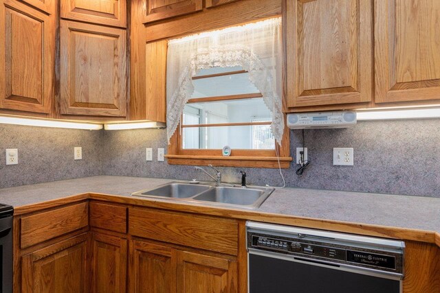 kitchen with black dishwasher, sink, and backsplash