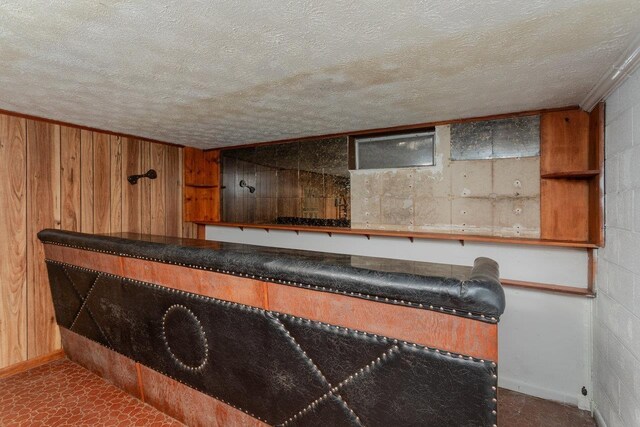 bar with a textured ceiling and wood walls