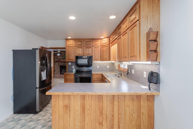 kitchen with stainless steel fridge with ice dispenser, sink, decorative backsplash, electric range, and kitchen peninsula