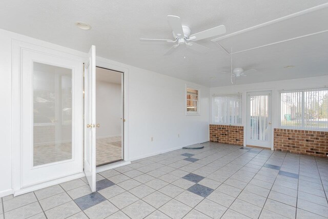 empty room featuring ceiling fan and light tile patterned floors