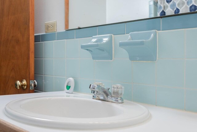 bathroom with sink and tile walls