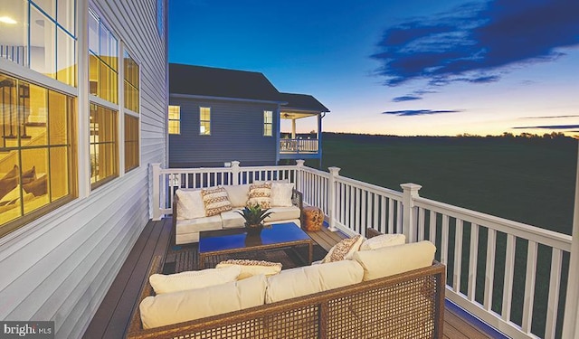 deck at dusk with a water view and an outdoor hangout area