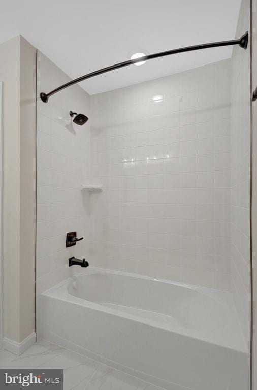 bathroom with marble finish floor and shower / bathing tub combination