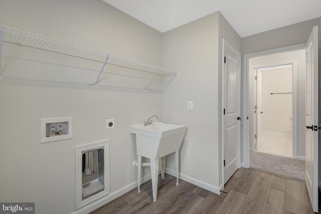 washroom with washer hookup, electric dryer hookup, light wood-type flooring, laundry area, and baseboards