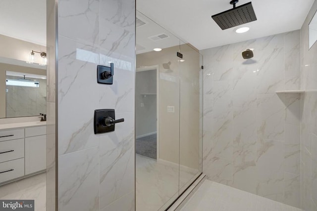 bathroom with marble finish floor, a marble finish shower, visible vents, and vanity