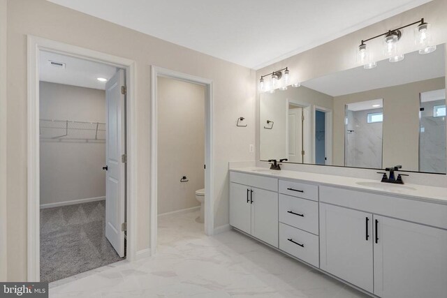 full bathroom featuring a walk in closet, marble finish floor, visible vents, toilet, and a sink