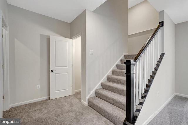 staircase featuring carpet floors and baseboards